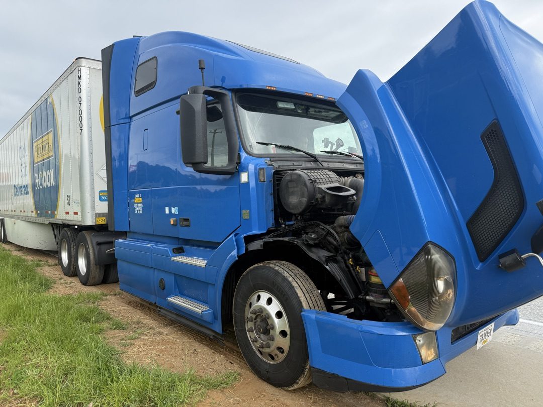 Blue Volvo VNL with hood tilted forward, engine exposed